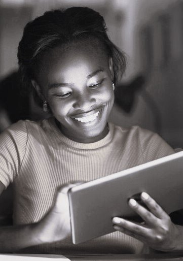 photo of a lady smiling at a tablet while doing research