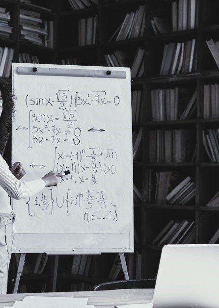 photo of a tutor writing on a whiteboard in front of a laptop